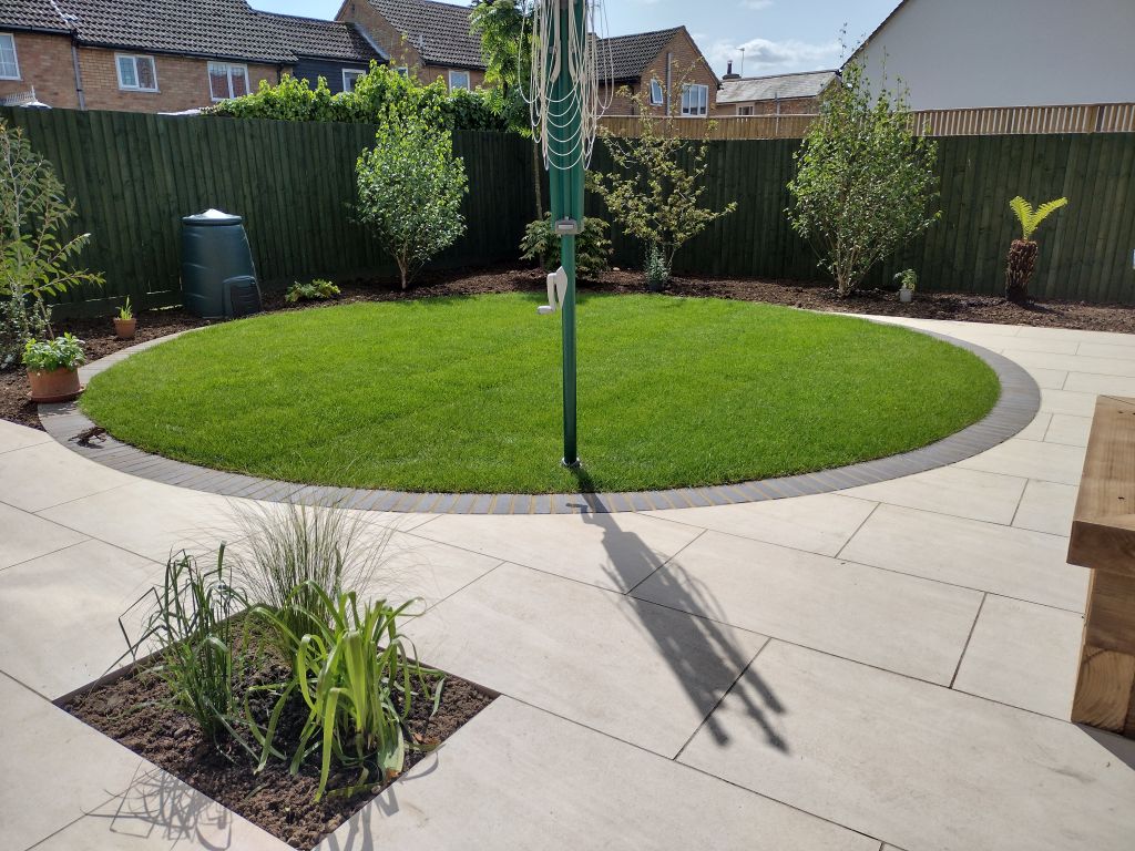 Circular lawn set within porcelain paving.