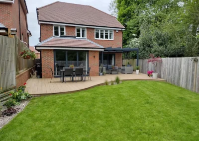 House with curvilinear deck and lawn.